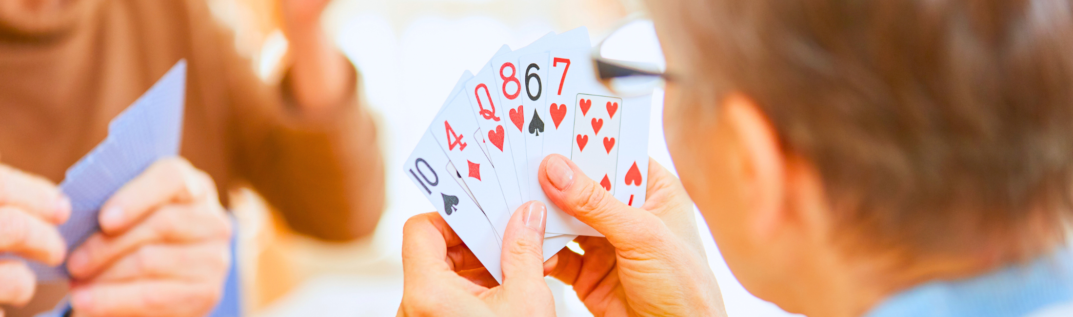 Senior woman holding cards across from opponent